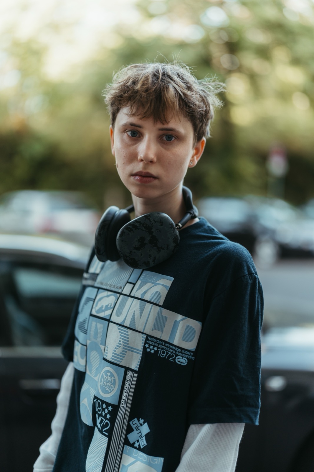 A young adult wearing headphones outdoors