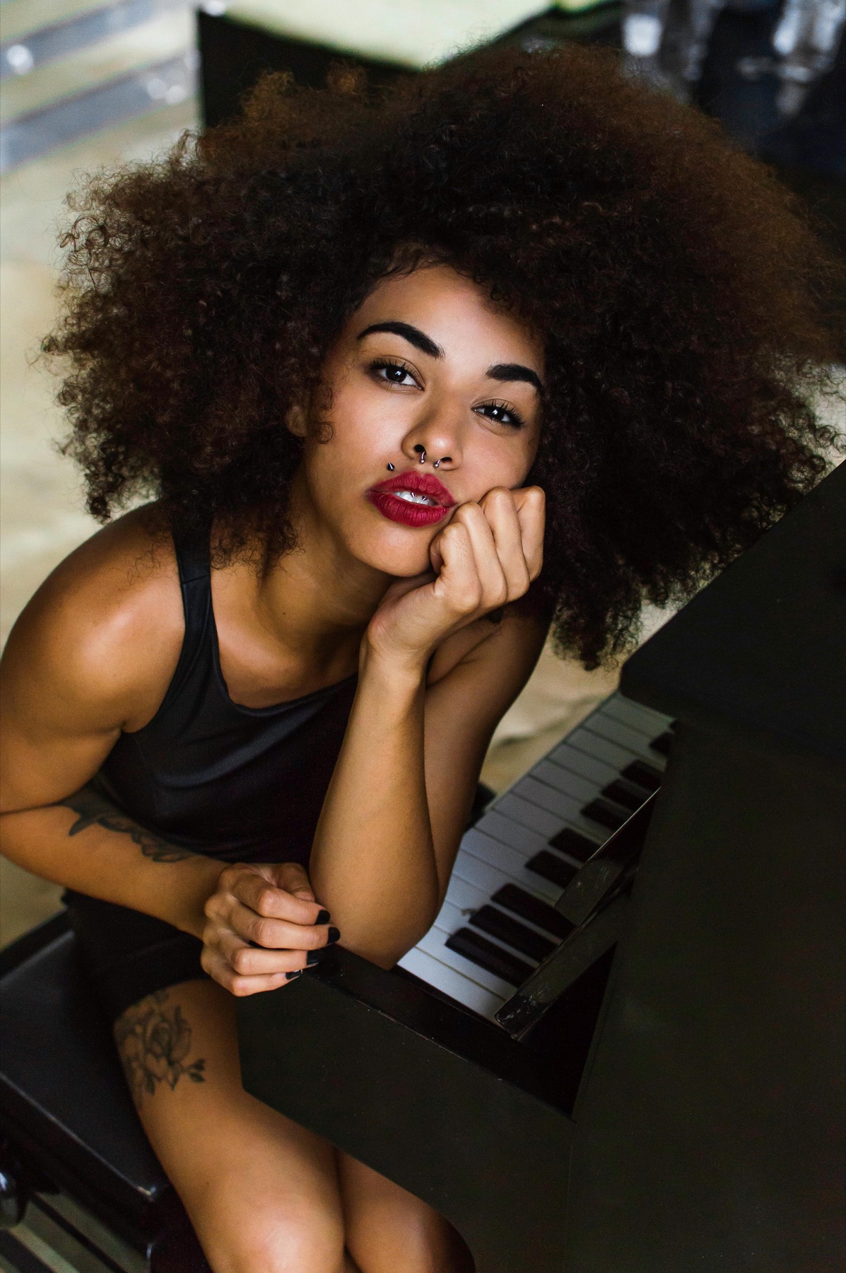 A woman seated beside a piano